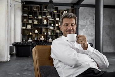 Portrait of mature man enjoying cup of coffee in loft - PDF01605