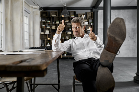 Portrait of mature businessmanshowing thumbs up stock photo