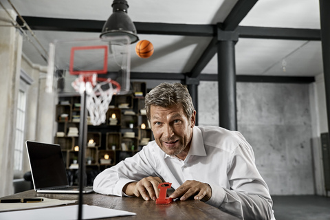 Portrait of mature business man playing office games in loft stock photo