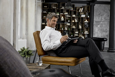 Mature man using digital tablet with digital pen in loft - PDF01626