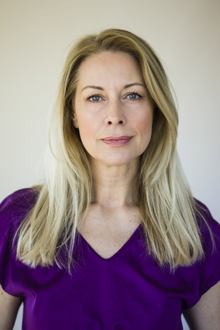Portrait of blond mature woman wearing purple top stock photo
