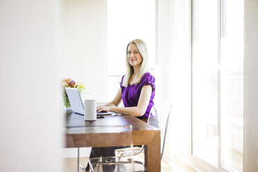 Portrait of smiling businesswoman working on laptop - MOEF01052