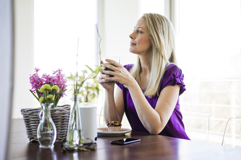 Mature woman sitting at table relaxing with glass of coffee stock photo