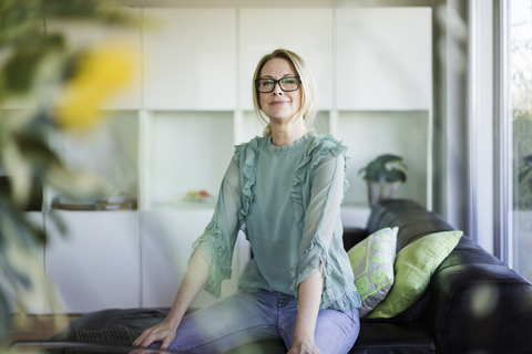 Portrait of content businesswoman sitting on couch stock photo