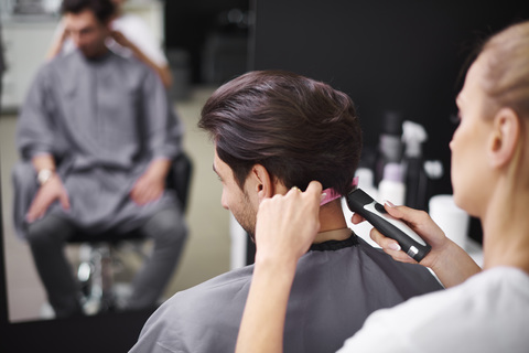 Friseur schneidet einem Mann die Haare, lizenzfreies Stockfoto