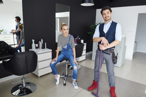 Portrait of confident hairdresser and woman in hair salon stock photo