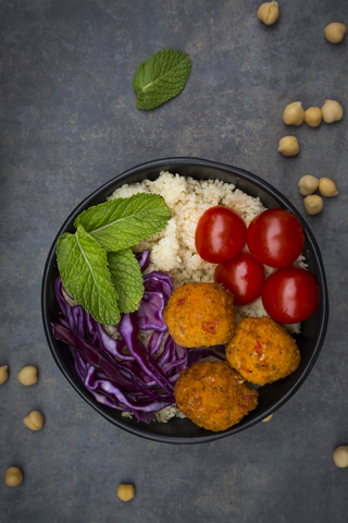 Couscous sweet potato falafel bowl with red cabbage, tomato, mint and hummus stock photo