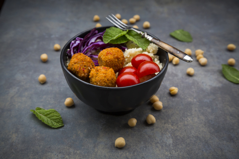 Couscous sweet potato falafel bowl with red cabbage, tomato, mint and hummus stock photo