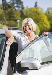 Smiling woman with car door - MASF06864