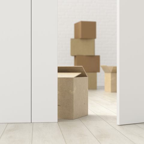 Cardboard boxes in a room behind ajar door, 3d rendering stock photo