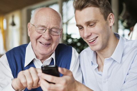 Junger Mann und alter Mann hängen zusammen ab, lizenzfreies Stockfoto