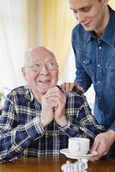 Junger Mann serviert Kaffee an Seniorin - MASF07032