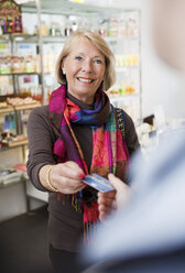 Frau gibt Verkäuferin Kreditkarte - MASF07055