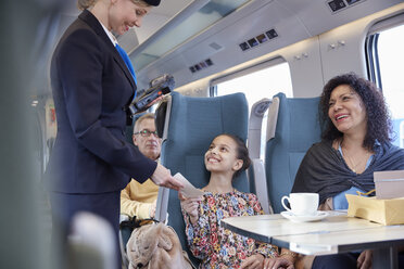 Zugbegleiter bei der Fahrkartenkontrolle von Mutter und Tochter im Personenzug - CAIF20243