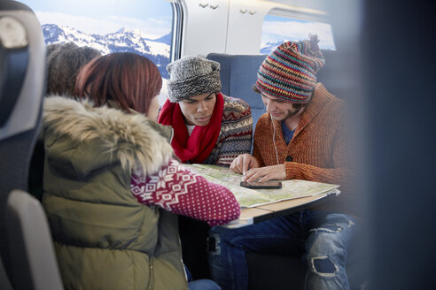 Junge Freunde mit Kartenplanung im Personenzug - CAIF20254