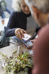 Woman with smart phone using contactless payment - CAIF20275