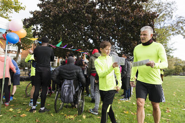 Vater und Sohn mit Marathon-Startnummern beim Wohltätigkeitslauf im Park - CAIF20306