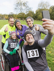 Mann im Rollstuhl macht Selfie mit Freunden bei Wohltätigkeitsrennen im Park - CAIF20310