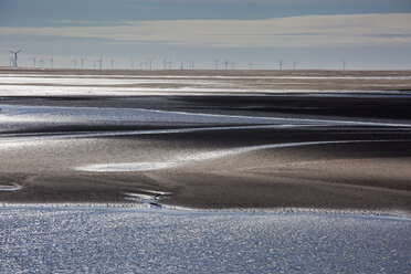 Wind turbines in distance beyond bay, Morecambe Bay, UK - CAIF20350
