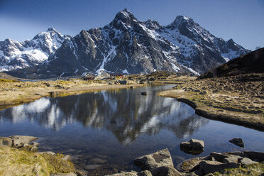 Schnee auf abgelegenen, sonnigen, zerklüfteten Bergen über dem Wasser, Maervoll, Lofoten, Norwegen - CAIF20356