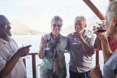 Glückliche aktive ältere Freunde trinken Wein auf dem Balkon - CAIF20360