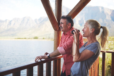Ehepaar mit Fernglas genießt den Seeblick vom Balkon - CAIF20380