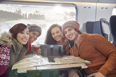 Glückliche junge Freunde mit Karte nehmen Selfie mit Selfie-Stick auf Passagierzug - CAIF20404