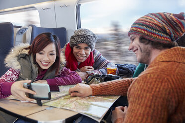 Junge Freunde mit Karte nehmen Selfie mit Selfie-Stick auf Personenzug - CAIF20411