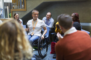 Lächelndes Publikum, das einer Rednerin mit Mikrofon im Rollstuhl zuhört - CAIF20441