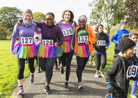 Lächelnde Läuferinnen in Tutus beim Wohltätigkeitslauf im Park - CAIF20471