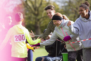 Zuschauer bejubeln Läufer beim Wohltätigkeitslauf im Park - CAIF20501