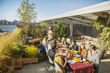 High angle view of friends having meal at outdoor table during garden party - CAVF48213