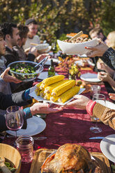 Ausgeschnittenes Bild von Freunden, die sich das Essen am Tisch im Freien während einer Gartenparty reichen - CAVF48215