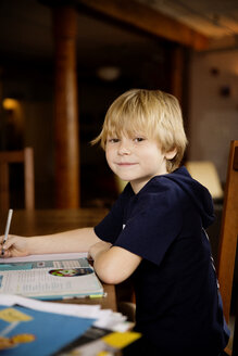 Side view portrait of cute boy studying at table - CAVF48263