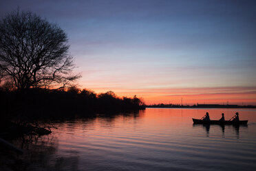 Silhouette Frauen Ruderboot auf See gegen Himmel bei Sonnenuntergang - CAVF48375