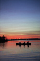Silhouette Freunde Ruderboot auf See gegen Himmel bei Sonnenuntergang - CAVF48376