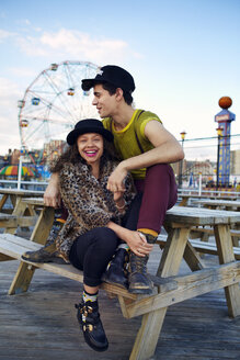 Glückliche Freunde sitzen am Picknicktisch auf Coney Island - CAVF48377