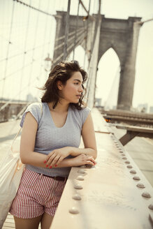 Nachdenkliche Frau auf der Brooklyn Bridge in der Stadt - CAVF48395