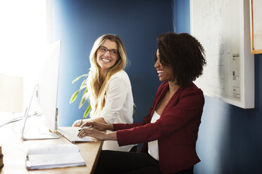 Smiling businesswomen working in office - CAVF48631