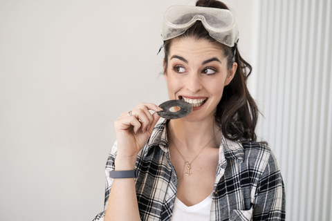 Young woman renovating her new flat, biting grinding disc stock photo