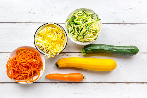 Zoodles, green and yellow zucchini, carrot on white wood - SARF03675