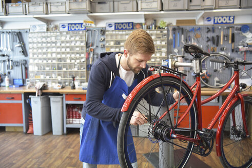 Fahrradmechaniker bei der Arbeit in seiner Reparaturwerkstatt - LYF00812