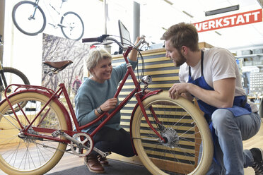 Salesperson helping customer in bicycle shop - LYF00825