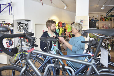 Salesperson helping customer in bicycle shop - LYF00835