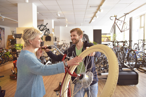 Salesperson helping customer in bicycle shop stock photo