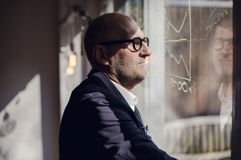 senior Businessman beim Brainstorming, Formeln auf Fensterscheibe zeichnen - GUSF00679