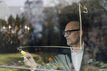 senior businessman brainstorming, drawing formulas on window pane - GUSF00709