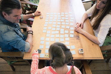 Family playing memory on table at home - MOEF01070