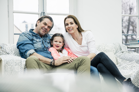 Portrait of happy family sitting on couch stock photo