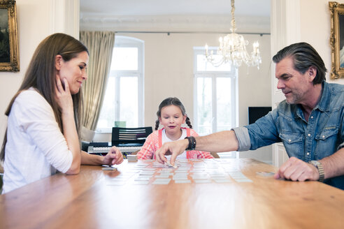 Family playing memory on table at home - MOEF01074